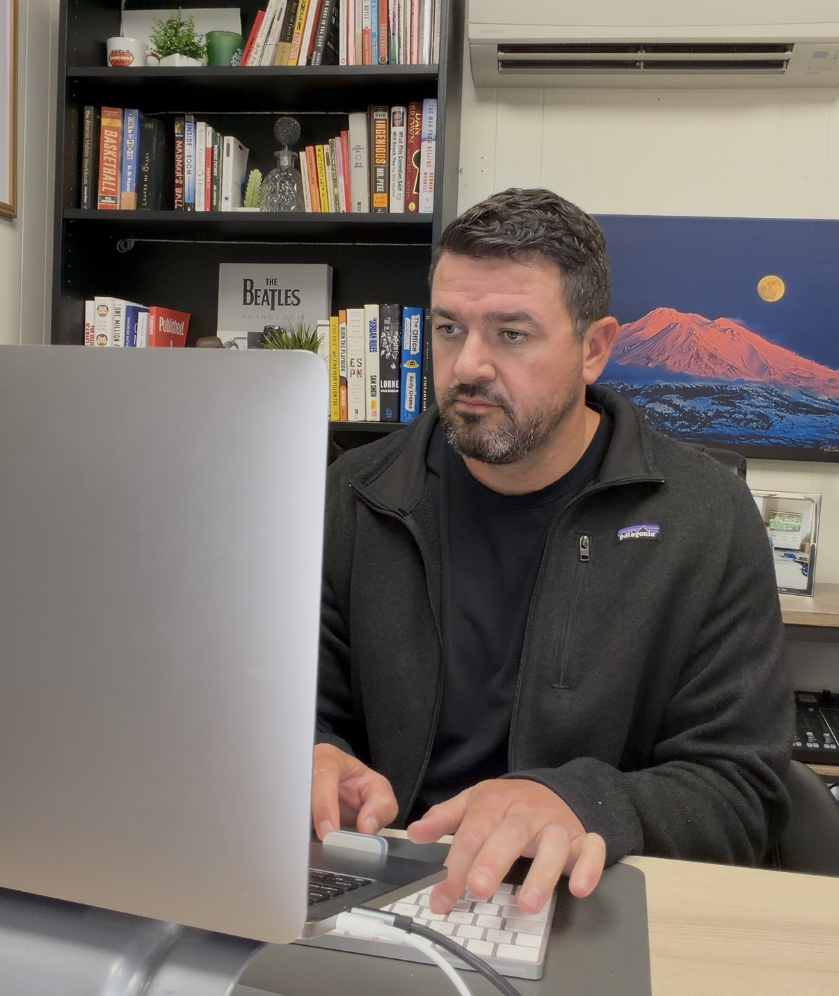 Zach O'Brien reviewing a newsletter draft at his desk